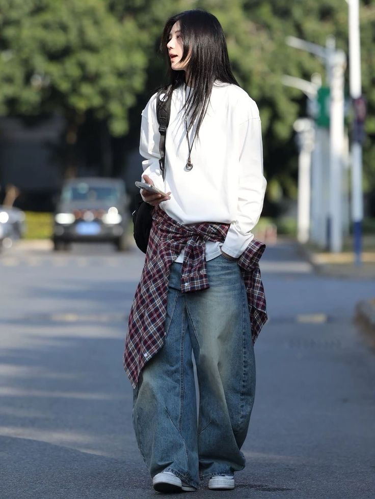 Streetwear – white sweatshirt, baggy jeans and a shirt with a pattern around the waist